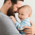 Loving father embracing his cute baby son