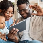 Black family having video call using tablet waving hands