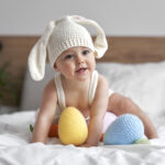Cute Girl Playing With Easter Toys On Bed At Home
