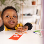 Toddler black boy and his beautiful mother using  game cards to learn and play