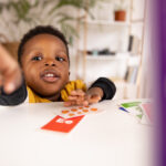 Toddler black boy and his beautiful mother using  game cards to learn and play